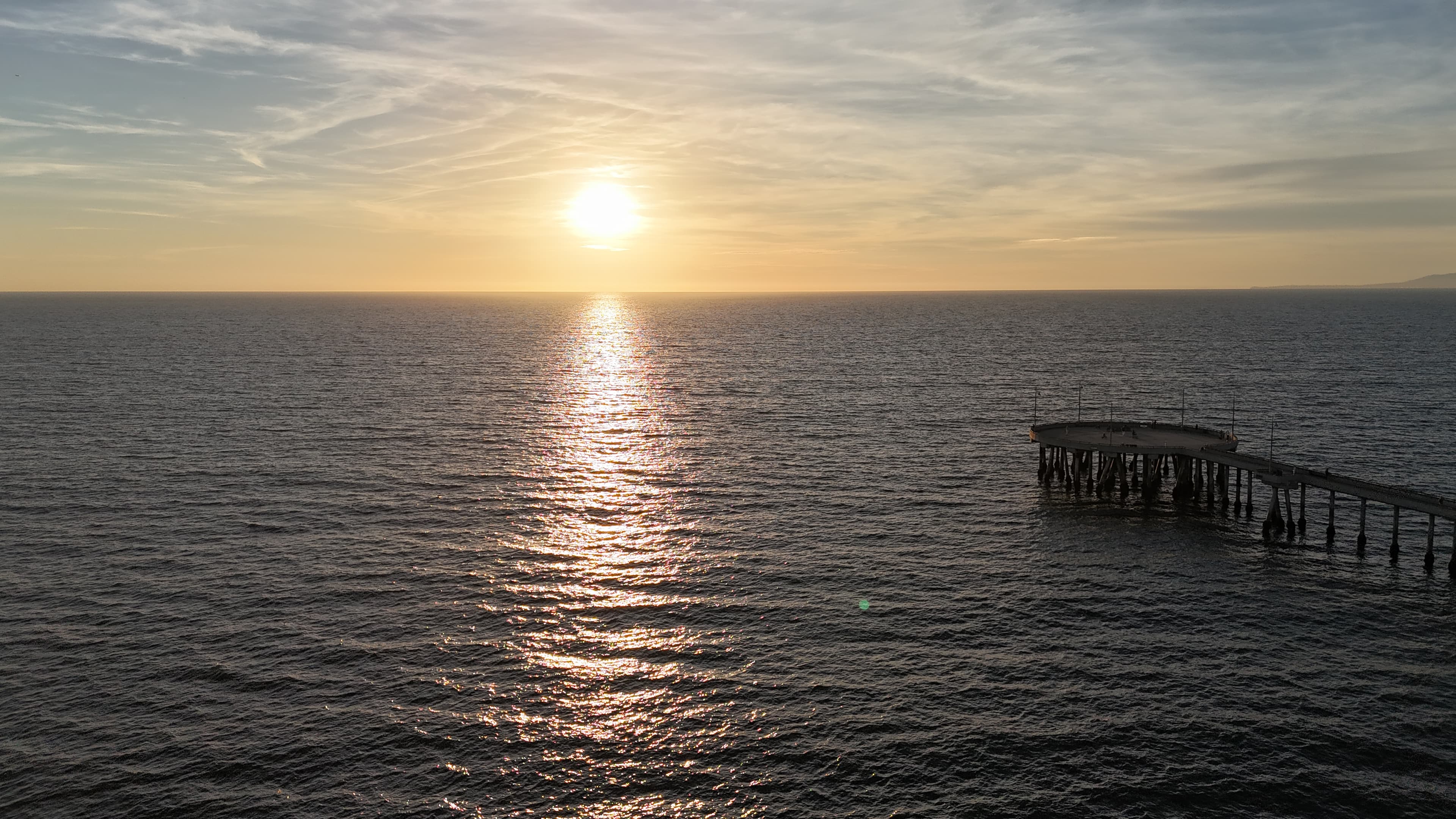Venice Pier at sunset with sun reflecting on the Pacific